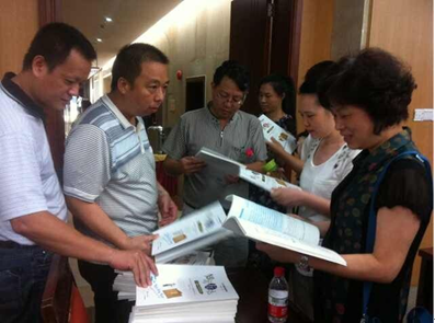 （圖二）張海鋒副校長(zhǎng)向與會(huì)人員贈(zèng)送教材